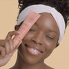 African American model applying Radiant & Bright Glowing Moisturizer to her hands and face which reduces the appearance of fine lines
