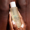 Woman holding bottle of USRX Super C Body Bright Oil