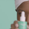 African American model applying the brightening powerhouse Even Tone Super Glow serum to her face