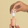 African America model applying Reti-Glow Resurfacing Night Oil to mix with moisturizer and foundation