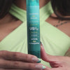 Woman holding bottle of USRX YouthHero AM/PM Serum which includes serums for morning and nighttime use for firmer and more even skin