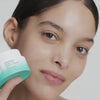 Woman applying USRX HydraBalance Brightening Moisture Infusion on her face